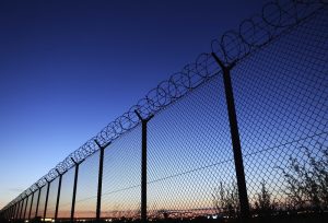 A wire fence with barbed wire on top